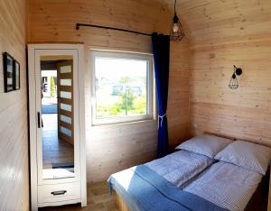 a bedroom with a bed in a wooden room at Domki Apartamentowe Rozgwiazdy 20 in Jarosławiec +43 photos