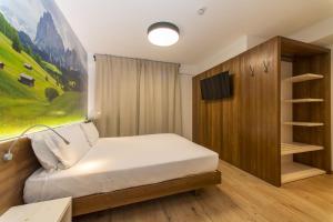 A bed or beds in a room at YUGOGO PELLICO 8 Trento Centro