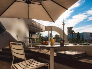 d'une table, d'une chaise et d'un parasol sur le balcon. dans l'établissement Campanile Nice Aéroport, à Nice