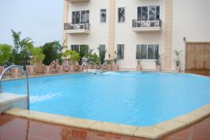 a large swimming pool in front of a building at Stung Sangke Hotel in Battambang