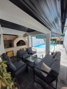 a living room with a couch and chairs and a pool at Apartman Kiss in Jajce