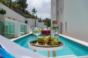 ein Tablett mit Weingläsern und Flaschen auf einem Tisch neben dem Pool in der Unterkunft Villa Smaragd - Perle - Luxury Apartments With Shared Pool in Makarska