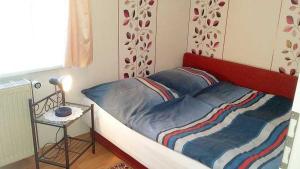 a bedroom with a bed with a red headboard and a table at Rügen Fewo 31 in Göhren