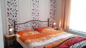 a bedroom with a bed with two orange pillows at Rügen Fewo 31 in Göhren