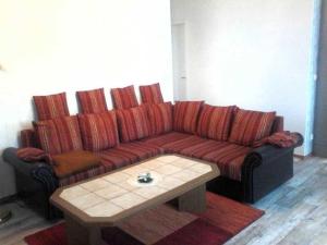 a red couch in a living room with a coffee table at Rügen Fewo 31 in Göhren +6 photos