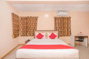 a bedroom with a large bed with red pillows at OYO 8116 Park Inn in Bangalore