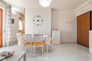 comedor con mesa y reloj en la pared en La Casa del Sole, en Selargius