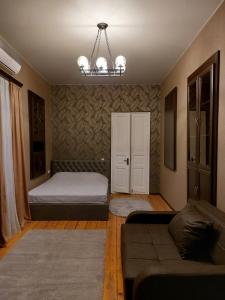 ein Schlafzimmer mit einem Bett, einem Sofa und einem Kronleuchter in der Unterkunft Resting Place in Tbilisi City