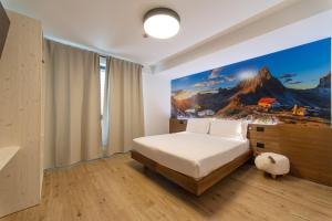 A bed or beds in a room at YUGOGO PELLICO 8 Trento Centro