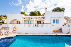 a villa with a swimming pool in front of a house at Villa Sol y Sombra by Escape Home in Son Bou