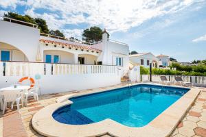 una villa con piscina di fronte a una casa di Villa Sol y Sombra a Son Bou