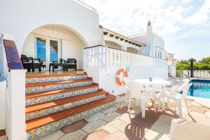 een villa met een zwembad en een patio met een tafel en stoelen bij Villa Sol y Sombra in Son Bou