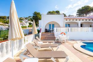 a villa with a pool and chairs and a house at Villa Sol y Sombra by Escape Home in Son Bou