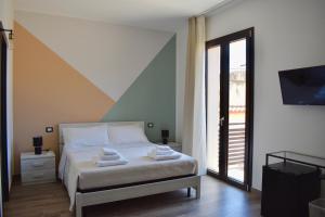 a bedroom with a bed with towels on it at Domus Solis in Pachino