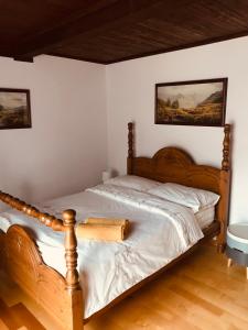 Nad Potokiem في Wapienne: غرفة نوم بسرير خشبي وصورتين على الحائط
