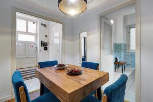 a dining room with a wooden table and blue chairs at Liberty Square Apartment in Budapest