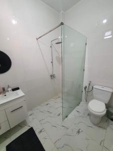un bagno con doccia in vetro e WC di La Baraka, extravagant villa for 8 with pool in Saly a Gandigal