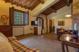 sala de estar con sofá y mesa con copas de vino en Agriturismo Casavaiano, en Gambassi Terme