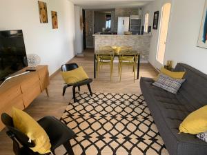 a living room with a couch and a table and chairs at Mon Ecrin sur la marina du Golfe de St Tropez in Cogolin
