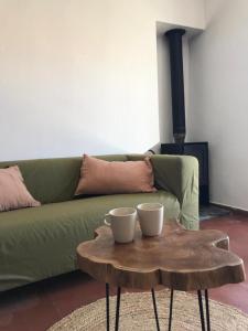 uma sala de estar com um sofá verde e uma mesa de centro em Azenhas do Mar Cottage by Lisbon Dreams em Sintra