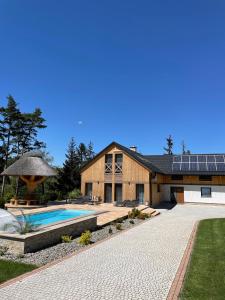 a house with a swimming pool in front of it at Rezydencja Spisz- dom 12 osób, podgrzewany basen, sauna, jacuzzi- velo Dunajec, Pieniny in Niedzica Zamek