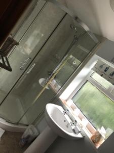 a bathroom with a glass shower and a sink at The Garden Cottage, Inglewhite in Inglewhite