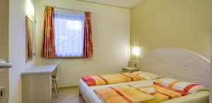 een kleine slaapkamer met een bed en een raam bij Elisa Bait Giobbe in Livigno +5 foto's