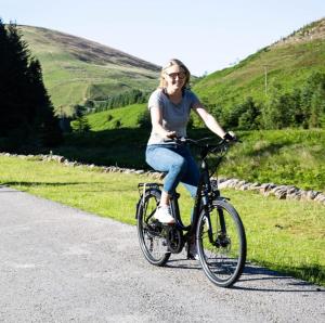 a woman is riding a bike on a road at The Garden Cottage, Inglewhite in Inglewhite