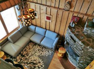 a living room with a couch and a stone fireplace at Rukanhelmi jr. in Ruka