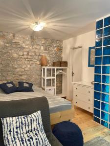 ein Schlafzimmer mit einem Bett und einer Steinmauer in der Unterkunft Art stone house Belle in Tribunj