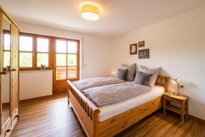 a bedroom with a wooden bed in a room at Ferienwohnung Brunnäcker in Bad Hindelang