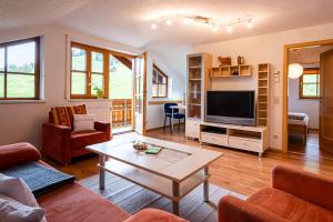 a living room with a couch and a tv at Ferienwohnung Brunnäcker in Bad Hindelang