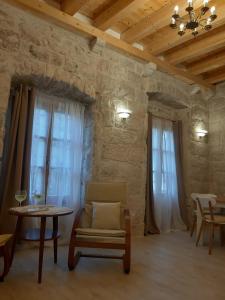 een woonkamer met een stoel, een tafel en ramen bij Sessa's Palace in Korčula