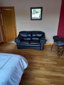 a black leather couch sitting in a room at Benbulben View F91YN96 in Sligo
