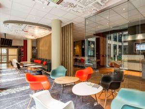 a lobby with colorful chairs and tables in a building at ibis München Parkstadt Schwabing in Munich