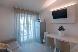 uma sala de estar com uma mesa e um frigorífico em Villa Zavatta "B&B - Rooms & Apartments" em Bellaria-Igea Marina