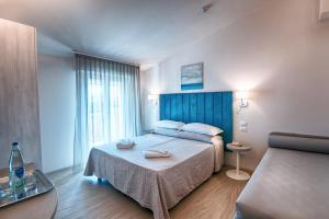 a bedroom with a large bed with a blue headboard at Villa Zavatta "B&B - Rooms & Apartments" in Bellaria-Igea Marina +61 photos