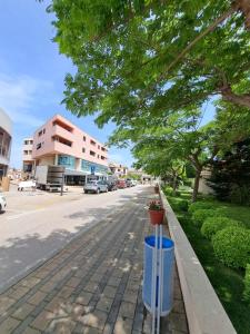 a street with a tree and a trash can at Apartman Karmen in Vodice