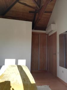 a bedroom with wooden ceilings and a bed and a cabinet at Quintinha dos Emigrantes in Cujó