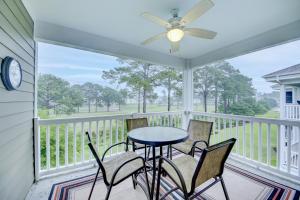 um alpendre coberto com uma mesa e cadeiras e uma ventoinha de tecto em Magnolia Pointe 305 em Myrtle Beach