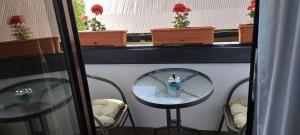 eine Spiegelung eines Tisches und Stühlen in einem Fenster in der Unterkunft B&B Popamuseum Tarpesti in Tîrpeşti
