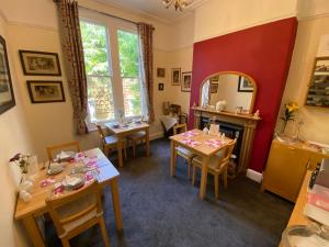 a dining room with two tables and a mirror at Cheriton Lodge in Burnham on Sea