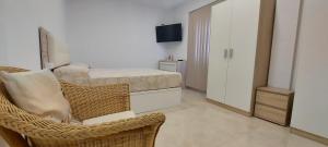 a bedroom with a bed and a chair and a television at LAS 7 ISLAS, BARRANCO DE ADEJE in Adeje