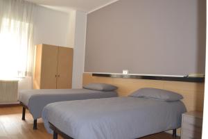 1 dormitorio con 2 camas y ventana en GARNI ANNA en Besenello