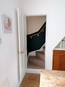 a hallway with a door leading to a stairway at Unique city centre house with log burner & courtyard in Norwich