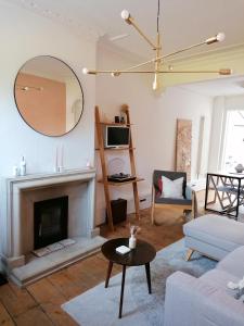 a living room with a fireplace and a mirror at Unique city centre house with log burner & courtyard in Norwich