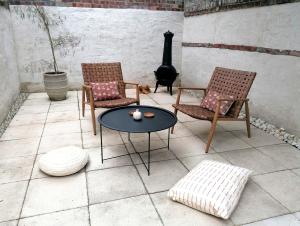 a patio with two chairs and a table and a stove at Unique city centre house with log burner & courtyard in Norwich