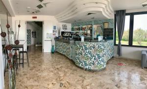 a restaurant with a counter and a bar in a room at Hotel Tritone Rimini in Rimini