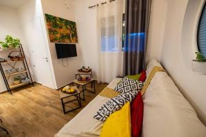 a living room with a couch and a television at Lemon Garden Stylish private apartment in Kalamata