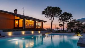 a swimming pool in front of a house at Villa California 6, Emma Villas in Saludecio